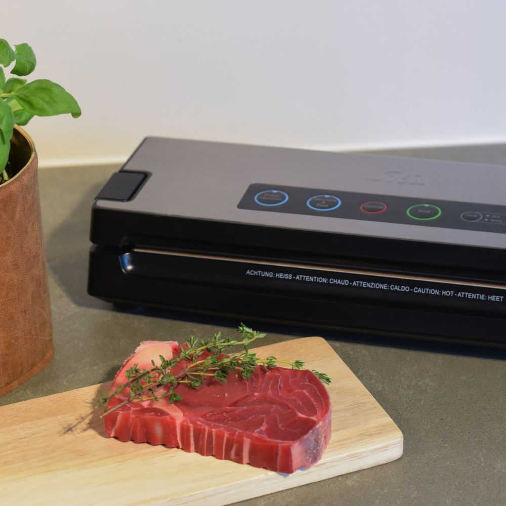 Solis Vac Premium Vakuumierer in der Küche mit frischem Fleischstück und Kräutern auf Schneidebrett